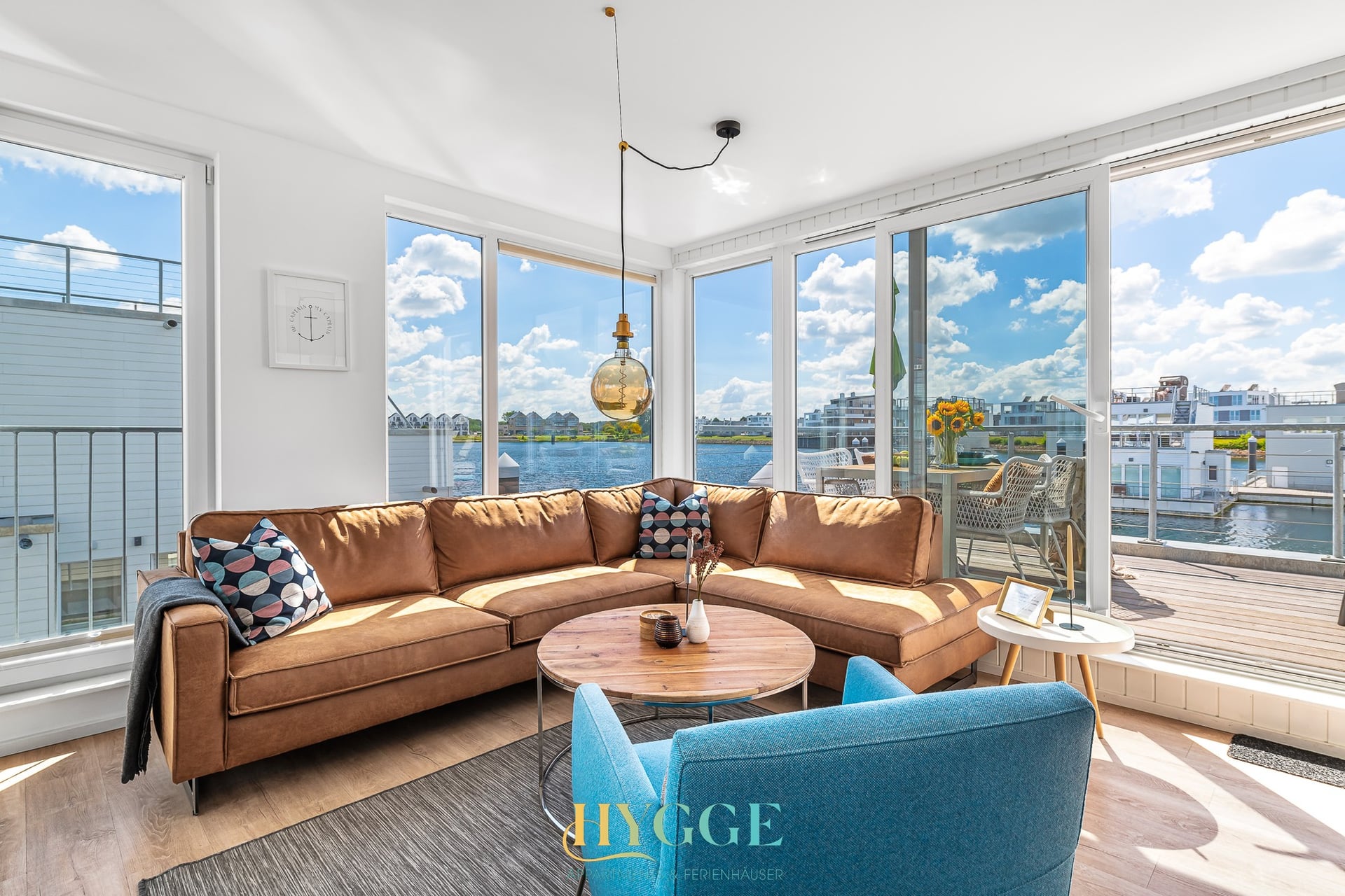 Wohnzimmer mit Panoramafenster und Wasserblick in Haus Hygge Schwimmhaus, Olpenitz
